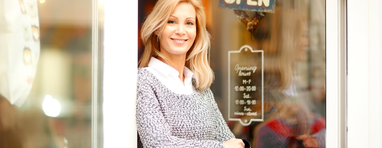 Woman standing in door of her business.